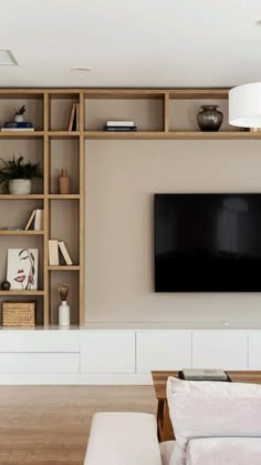 a living room filled with furniture and a flat screen tv mounted on a wall above it