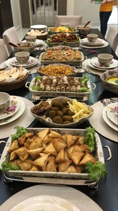 a table filled with lots of plates and bowls full of different types of food on it