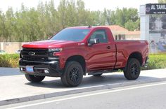 a red truck is parked on the side of the road