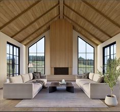 a living room filled with lots of furniture next to large windows on top of a wooden floor