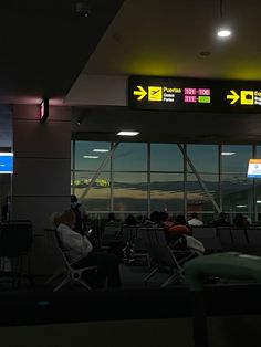 people sitting in chairs at an airport waiting for their luggage