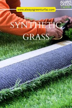 someone is cutting grass with scissors on the ground in front of an advertisement for synthetic grass