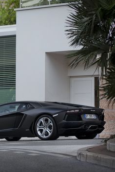 a black sports car parked in front of a building