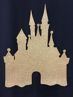 the silhouette of a castle is shown against a black background with gold flecks