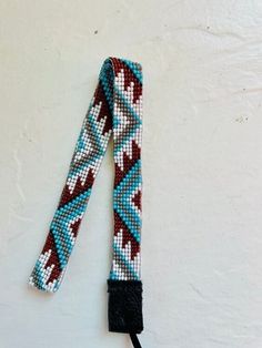 a blue and red beaded lanyard on a white surface