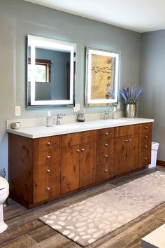 a bathroom with two sinks, a toilet and a large mirror above the vanity area