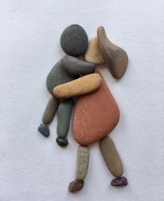 several rocks arranged in the shape of a person hugging one another with their arms around each other