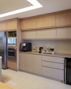 a modern kitchen with stainless steel appliances and wood cabinets