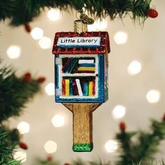 a little library ornament hanging from a christmas tree