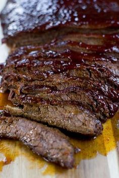 the steak is sliced and ready to be eaten on the cutting board with sauce all over it