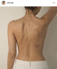 the back of a woman's body with tattoos on it