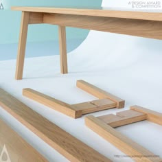 a wooden table and some pieces of wood sitting on the white floor next to each other