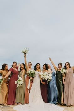 a group of women standing next to each other holding bouquets and flowers in their hands