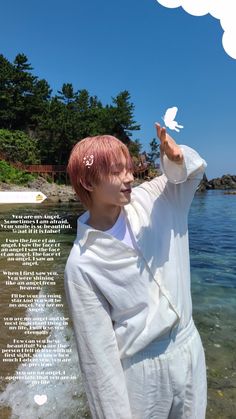 a man with pink hair standing in the water