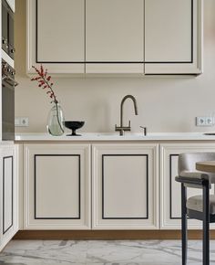 a kitchen with white cabinets and marble flooring is pictured in this image, there are two chairs near the sink