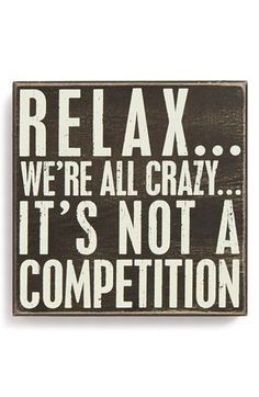 a sign that says relax we're all crazy it's not a competition