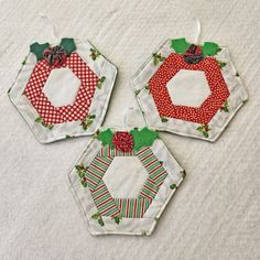 three small christmas ornaments on a white surface