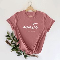 Auntie Est Shirt, Aunt Shirt, Customized Auntie Est Shirt, Birthday Gift Aunt Shirt, New Aunt Shirt, Cool Aunt T-Shirt, Aunt Life Shirt, Auntie Est Shirt,Aunt Shirt,Customized Aunt Tee,Bday Gift Aunt Shirt,New Aunt Shirt,Cool Aunt T-Shirt,Aunt Life Shirt,Auntie to be Shirt,Favorite Aunt Shirt,Baby Shower Shirt,Christmas Aunt Tee,Cute Aunt Shirt,Gift for Aunt Shirt  Welcome to my store! I'm absolutely thrilled to have you here. My main aim is to ensure your happiness and satisfaction. I value our Casual Slogan Tops For Birthdays, Casual Birthday Tops With Letter Print, Casual Slogan Tops For Birthday, Crew Neck T-shirt With Lettering For Gift, Casual Letter Print Top For Birthday, Casual Relaxed Fit Top For Birthday, Birthday Graphic Tee Shirt With Relaxed Fit, Relaxed Fit Graphic Tee Shirt For Birthday, Graphic Tee Shirt With Relaxed Fit For Birthday