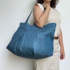 a woman is holding a large blue bag