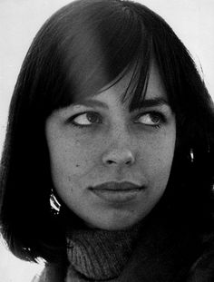 a black and white photo of a woman with short hair wearing a turtle neck sweater