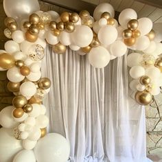 white and gold balloons are hanging from the ceiling