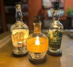 three bottles of alcohol sitting on top of a table