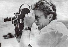 a man holding a camera up to his face and looking through it's lens