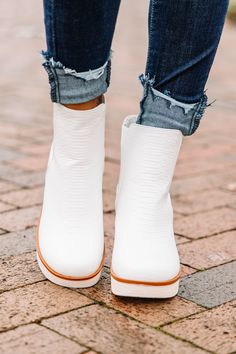 a close up of a person wearing white boots