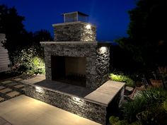 an outdoor fireplace lit up at night