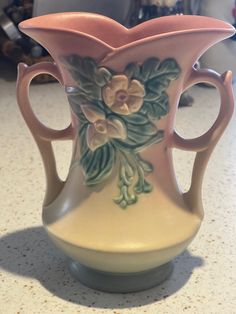 a ceramic vase with flowers painted on it