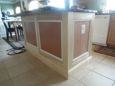 a kitchen island in the middle of a tile floor with cabinets and counter tops on it