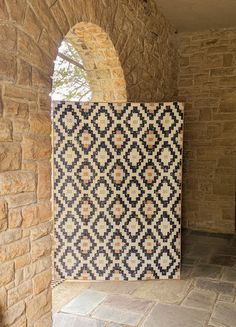 a decorative tile in the corner of a room with stone walls and arched doorways