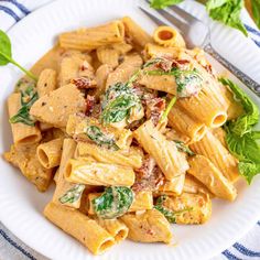 a white plate topped with pasta and spinach