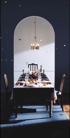 a dining room table is set with plates and glasses on it, in front of an arched doorway