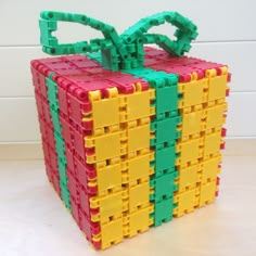 a cube made out of legos sitting on top of a wooden table next to a white wall