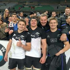 the rugby team is posing for a photo with their trophy and fans in the stands