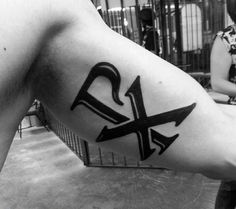 a person with a tattoo on their arm has an arrow in the shape of a letter