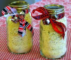 two jars filled with food sitting on top of a red and white checkered table cloth