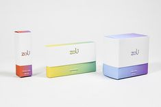 three boxes with different colors on them sitting next to each other in front of a white background