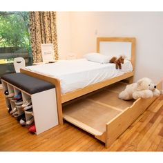 a bedroom with a bed, dresser and teddy bear on the floor next to it