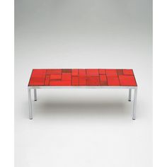 a red table sitting on top of a white floor