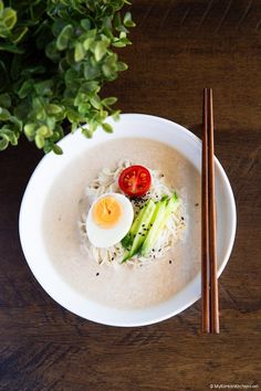 an overhead view of a bowl of ramen with chopsticks on the side