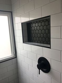 the corner of a bathroom with white tile and hexagonal pattern on the wall