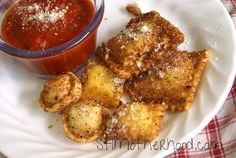 some fried food is on a white plate with a red and white checkered table cloth