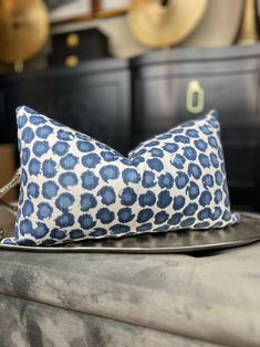 a blue and white pillow sitting on top of a metal tray