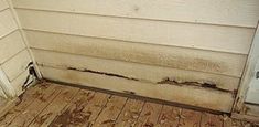 the corner of a house that has been gutted with wood flooring and water damage