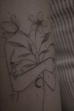 a woman's arm with flowers drawn on it