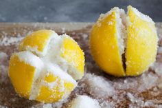 two peeled lemons sitting on top of a cutting board covered in powdered sugar