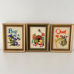 three framed cross - stitch pictures with words on them, one saying busy as a quilt and the other saying quiet as a button