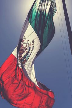 the mexican flag is flying high in the sky